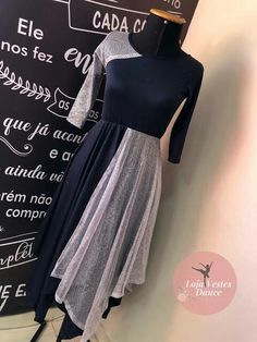 a mannequin is standing next to a black and white dress on display in front of a chalkboard