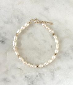 This  pearl bracelet is a beautiful staple piece!  Handmde with genuine freshwater pearls and little 14k gold filled accent beads. Perfect for your everyday and special looks! Please understand that every pearl is unique, and may resemble a different shape and size from the pearls in our photo!  - Each pearl measures 4-5mm. - Gold filled beads measure 3mm - Will not tarnish - Size up and wear as an anklet All of our jewelry is handmade with love in Nova Scotia, Canada. METALS Our jewelry is made White Beaded Pearl Bracelet 14k Gold Filled, White Beaded Pearl Bracelet With 14k Gold Filling, White Beaded Pearl Bracelet In 14k Gold Filled, White Beaded Pearl Bracelet In 14k Gold, White Pearl Drop Bracelet In 14k Gold Filled, White Pearl Drop Beaded Bracelets In 14k Gold Filled, 14k Gold Filled White Pearl Drop Bracelets, White 14k Gold Filled Pearl Drop Bracelets, White 14k Gold-filled Pearl Drop Bracelets