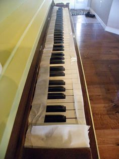 an old piano that has been covered with some white paper and is sitting on the floor