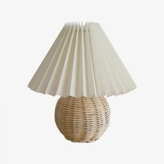 a wicker lamp with a white shade on it