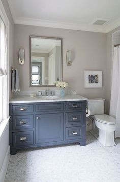 a white toilet sitting under a bathroom mirror next to a sink in a bath room