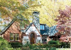 a brick house surrounded by trees in the fall