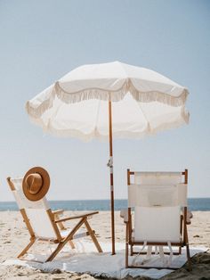 two chairs and an umbrella on the beach