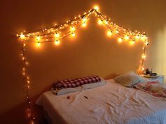 there is a bed with lights on the headboard