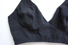 a close up of a black sports bra on a white surface with the bottom part visible