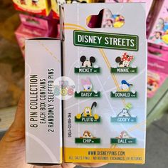 someone is holding up a disney street pin set