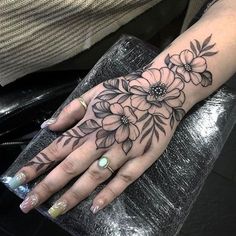 a woman's hand with flowers on it