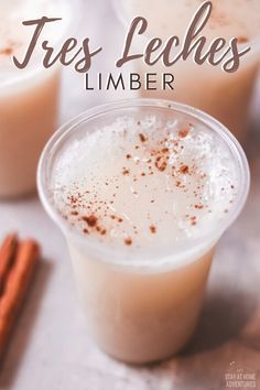 two glasses filled with ice cream and cinnamon on top of a table next to some cinnamon sticks