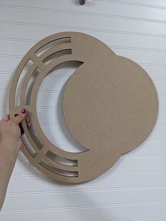 a person is making a paper cut out of a circle with scissors on the wall