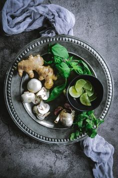 a metal plate topped with different types of food on top of a gray tablecloth