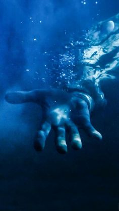 an underwater hand reaching out to the water