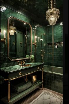 a green tiled bathroom with gold fixtures and chandelier above the sink, along with a large mirror on the wall