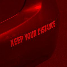 a red car with the words keep your distance on it