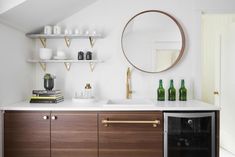 a kitchen with wooden cabinets and white counter tops, gold pulls on the door handles