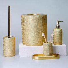 gold bathroom accessories on white surface with grey background