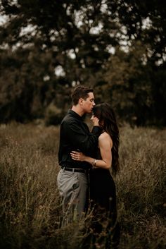 a man and woman standing in tall grass