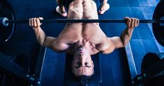 a shirtless man doing exercises on a barbell