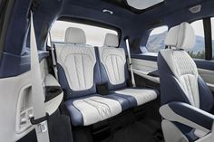 the interior of a vehicle with white and blue leather seats