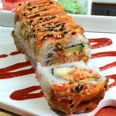 a white plate topped with a cut in half sushi roll on top of a table