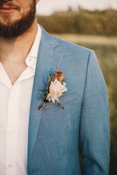 a man in a blue suit with a boutonniere on his lapel