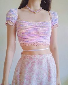 a woman wearing a crochet top and skirt