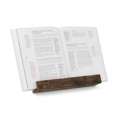 an open book sitting on top of a wooden stand