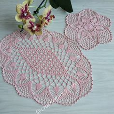 crocheted doily with flowers and leaves on the table next to each other