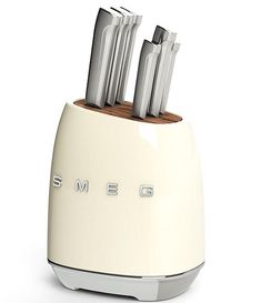 a white toaster with four knives sticking out of it's sides and the word smeg on top