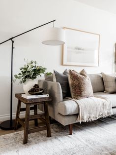 a living room filled with furniture and a large white rug on the floor next to a lamp