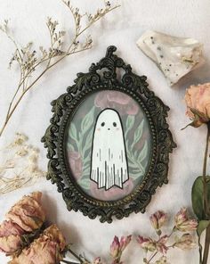 there is a picture of a ghost in the frame with flowers and leaves around it