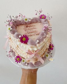 a cake in the shape of a heart being held by a hand