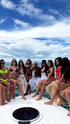 a group of women sitting on the back of a boat posing for a photo together