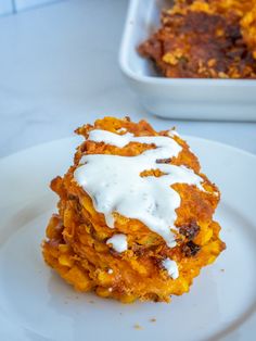 a white plate topped with food next to a casserole dish