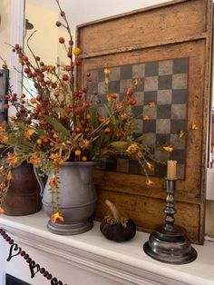 two vases filled with flowers sitting on top of a mantle