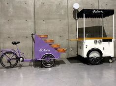 an ice cream cart next to a purple bike