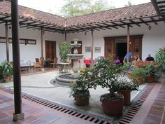 an outdoor courtyard with potted plants and chairs