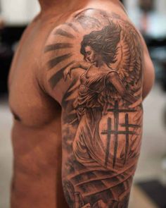 a man with a cross and angel tattoo on his arm