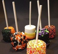 there are many different colored candies on the table with candles sticking out of them