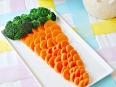 carrots and broccoli arranged on a white plate