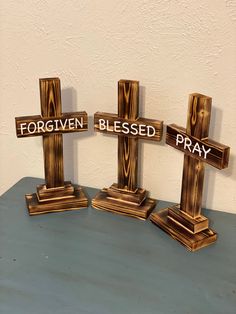 three wooden crosses sitting on top of a table with the words for given, blessed, pray