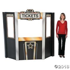 a woman standing in front of a ticket kiosk with the word tickets on it