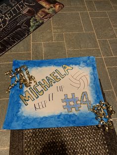 a cake that is on the ground with some writing on it and a book in the background