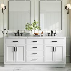 a white bathroom with double sinks and mirrors