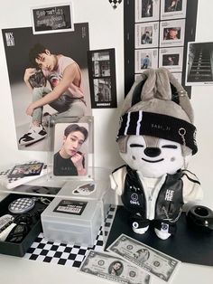 a stuffed animal wearing a hat next to other items on a table with pictures and money