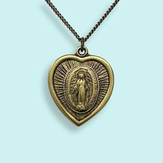 The legend of the Virgin of Guadalupe is that she first appeared to an Indigenous shepherd near Mexico City in 1531 and asked him to build a temple in her honor. Since then she’s become a beloved symbol in Mexico and beyond, representing faith, compassion and comfort to the oppressed. ⠀ Vintage Virgin of Guadalupe saint medal on aged brass curb chain. 18" chain Metal: 24kt gold plate over brass on pendant, aged brass chain Size: 1" wide pendant Lobster Clasp Nickel free The Virgin Of Guadalupe, Billy T, Virgin Of Guadalupe, Retro Brand, Saints Medals, 24kt Gold, Gift Card Shop, Aged Brass, Brass Chain