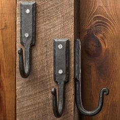 two metal hooks are attached to wooden boards