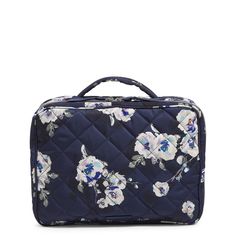 a blue floral suitcase with white flowers on the front and bottom, sitting against a white background