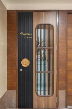 a wooden door with metal bars on the side and a round glass window above it