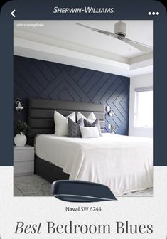 a bedroom with blue accent wall and white bedding