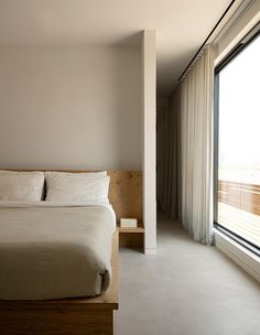 a bed sitting next to a window in a bedroom